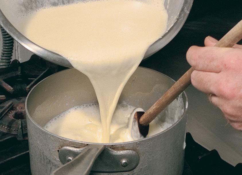 Tempering is completed by whisking the hot-milk/egg-yolk/ sugar mixture back into the remaining hot milk. The custard is ready to continue cooking at a low temperature.