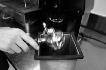Avoid securing the portafilter too tightly. Press the appropriate button for regular or decaf to turn the grinder on. Remove the portafilter when the grinder stops running.