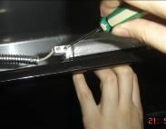 Use a flathead screwdriver to loosen the four screws locking the bulb in place.