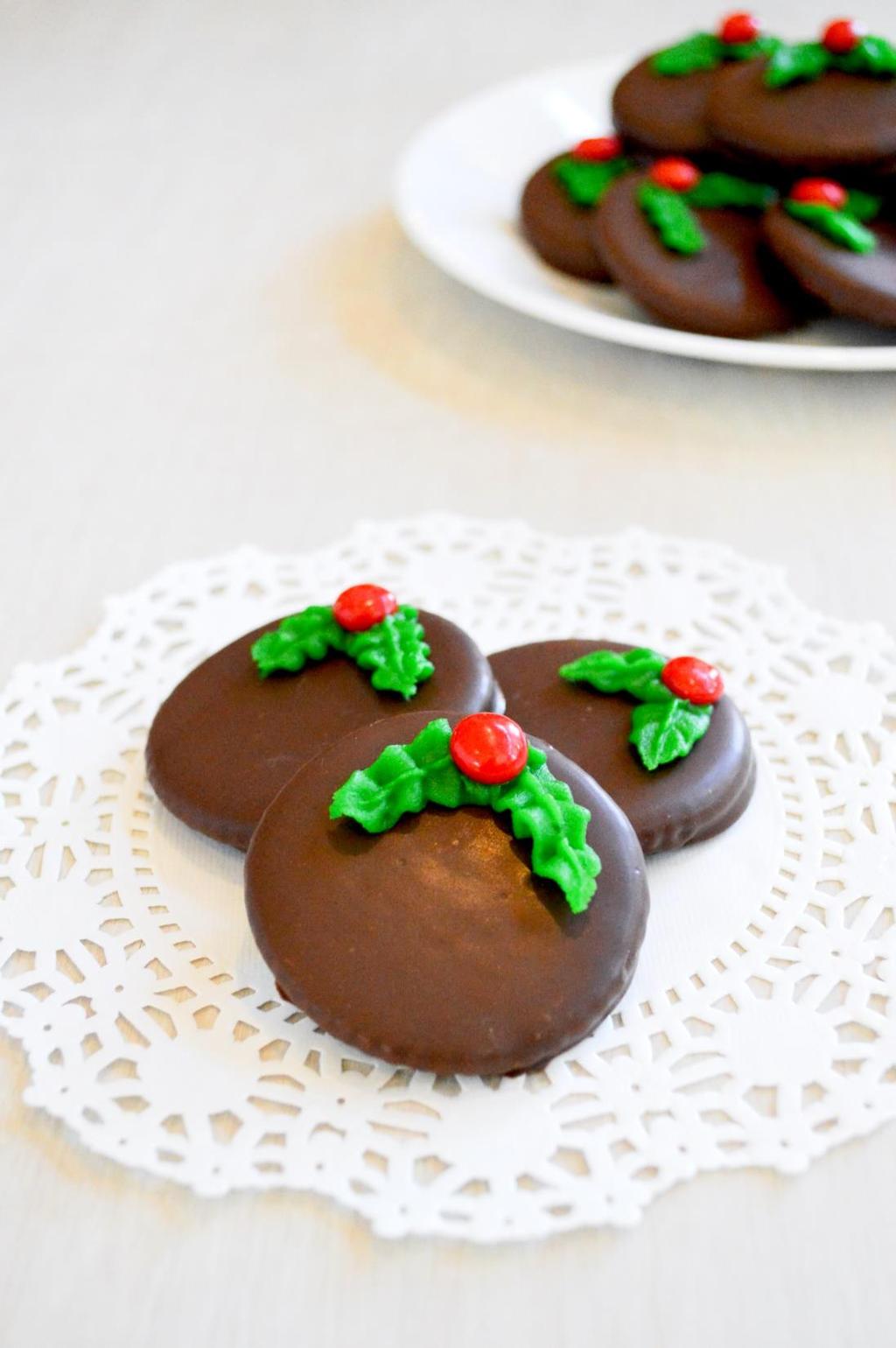 12 ounces chocolate 1 to 4 teaspoons shortening 1/4 teaspoon peppermint oil Approximately 48 round butter crackers Green decorating frosting Cinnamon red hot candies Melt the chocolates and 1