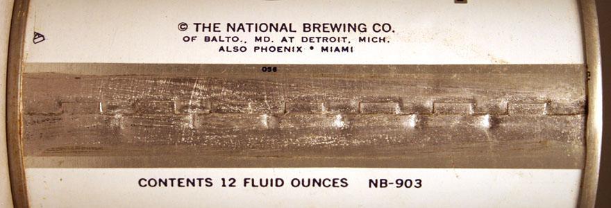 Seems pretty obvious the NB is for National Brewing and the 308 and 903 either plant number or additional canning code/design info: Colt 45 Pull Tab - 1 The above design has numerous minor canning