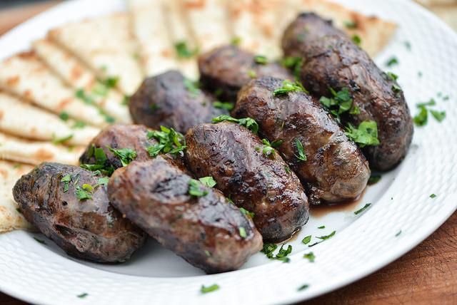 Sheftalia Sheftalia is a delicious charcoal grilled dish. It consists of minced meat shaped into small sausages, wrapped in panna (suet).
