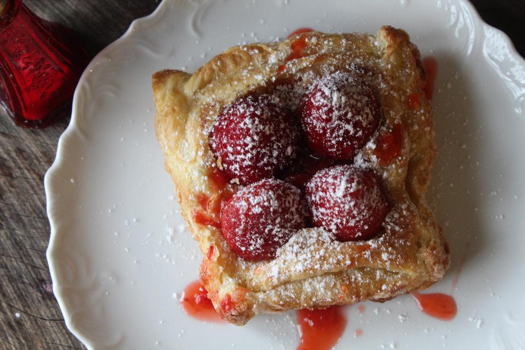 Fresh Berry Tarts 2 sheets of puff pastry 4 TB water 6 TB white sugar 1 cup strawberry jam 32 whole strawberries Powdered sugar Flaky and buttery puff pastry filled with simply sweet strawberry jam