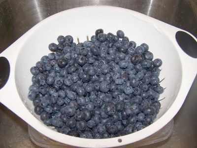 I put a colander or strainer in a large bowl, fill it with cold water and swirl the berries in it with my fingers.