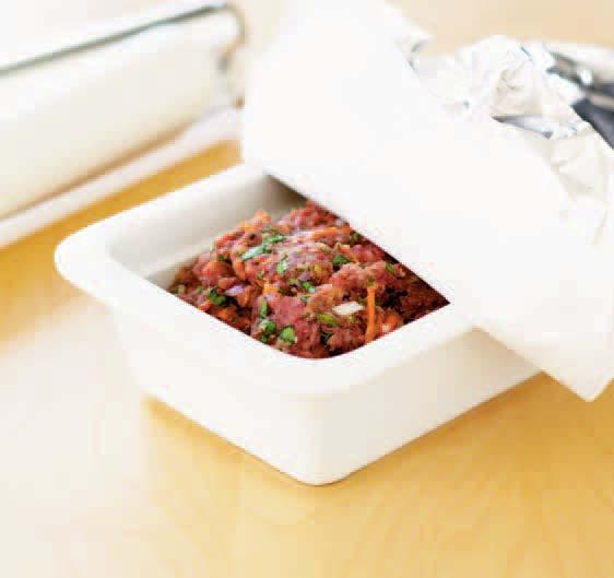 Pull the foil and paper back a couple of times during cooking and drain away the liquid to stop the meatloaf stewing rather than baking.
