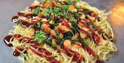 Hiroshima style Okonomiyaki consists of cooked layers of vegetables and noodles served with a special sauce on top.