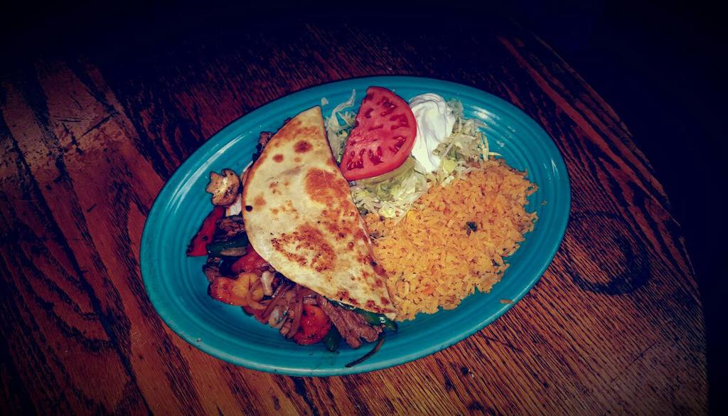 FAJITA CHIMICHANGA A flour tortilla stuffed with your choice of steak or chicken cooked with onion, tomatoes, bell peppers and mushrooms. Topped with cheese sauce, lettuce, sour cream and guacamole.