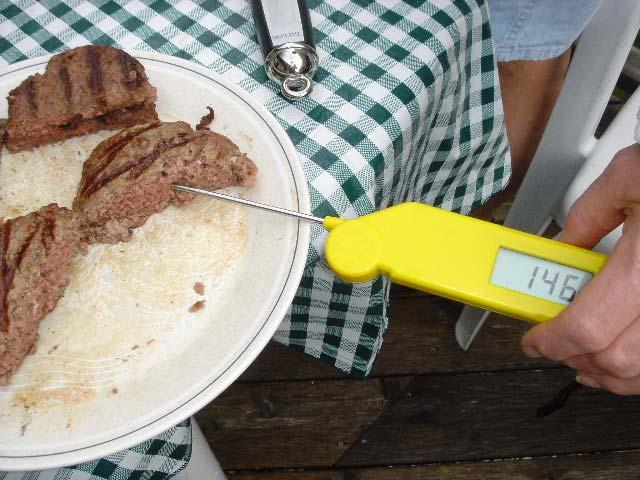 Figure 5 shows the temperature of a cut 8-oz. hamburger and the red appearance of the hamburger. Figure 6 shows a fork-type thermistor thermometer being used to check the temperature of an 8-oz.