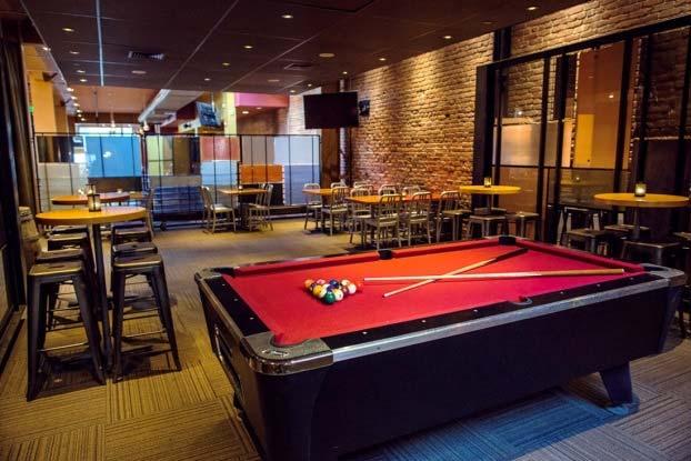 The room has a pool table and seating for 32 guests at a combination of tall cocktail tables with stools and regular tables with chairs.