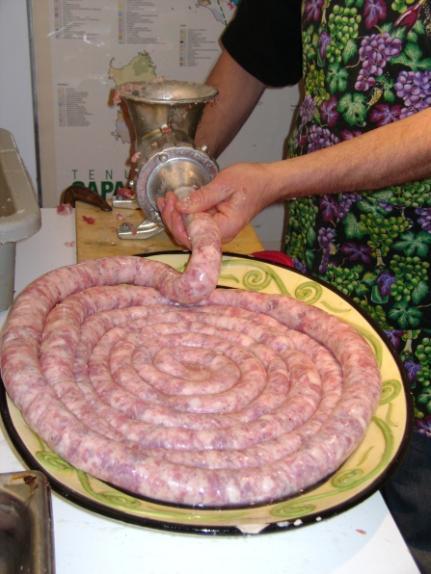 Two people are needed: one to turn the level and stuff the meat balls into the opening and one to stuff the sausages.