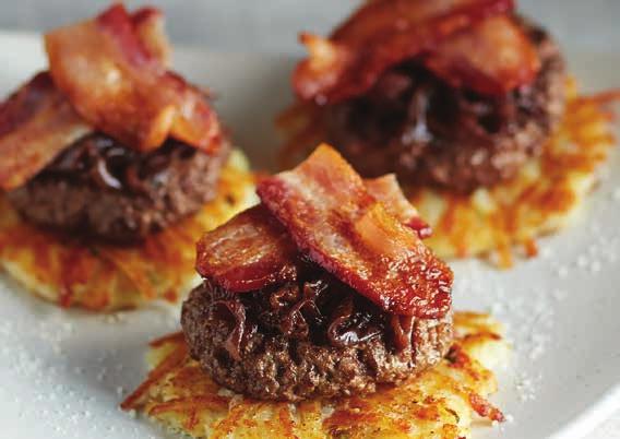 PARMESAN HASHBROWN SLIDERS A trio of savory hamburger sliders plated over hashbrown patties and smothered in a hot bacon