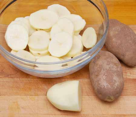 18 Slice the potatoes and place in a large bowl with ¼ cup olive oil. Turn to coat evenly.