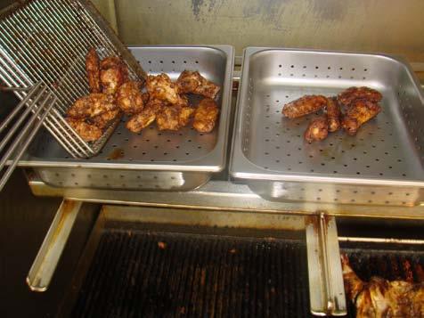 Using the wing basket, scoop the grilled Chicken Wings and place them inside the ½ size 2 deep perforated pan (Figure 8).