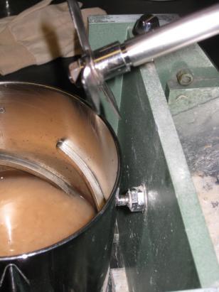 Figure 7: On the left, the heated pulp being poured into disintegrator apparatus; on the right, the vessel must touch the sensor stub in order for the disintegrator to operate.
