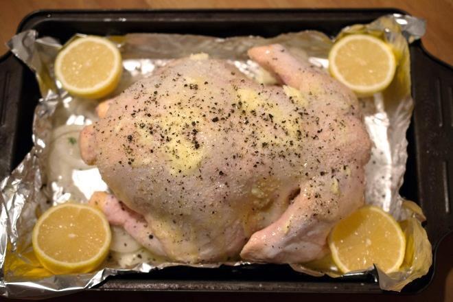 Drizzle the oil on the chicken and rub it all over the skin. Season generously inside and out with salt and pepper. Place the lemon, garlic, and herbs inside the cavity.