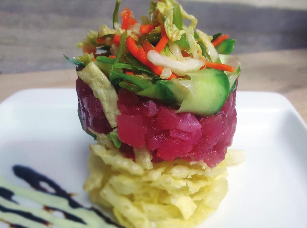 ahi tuna stack * A true original. Layers of crispy wontons, fresh avocado, ahi tuna poke, and pickled cucumber, finished with wasabi aioli and Guinness-soy reduction. Served with a petite Asian salad.