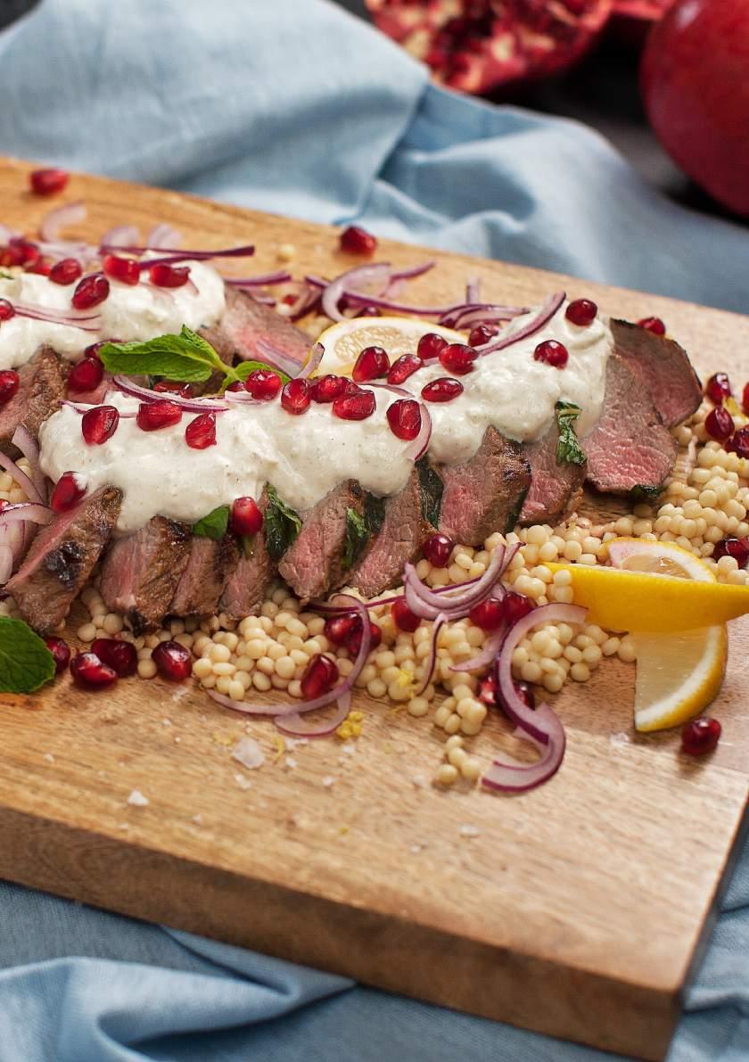 Minted Lamb with Fetta & Yoghurt Barbecued lamb back strap served sliced and drizzled with spiced fetta, pomegranate seeds and yoghurt.