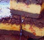 Orange Goji Custard Squares Base and Topping: 4 cups walnuts 2½ cups dates (soaked 30 minutes and drained) ½ cup cocoa or cacao powder 4 teaspoons vanilla essence Place walnuts into food processor