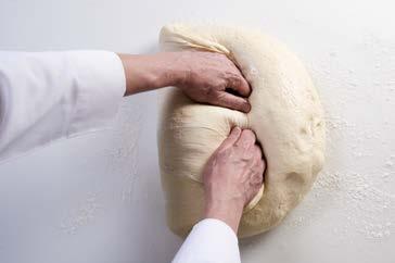 After folding, if more bulk fermentation is needed, return the dough to the fermentation container.