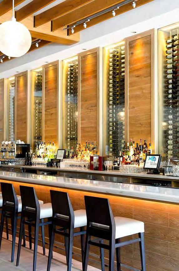 The sparkling, glass-encased wine cellar frames the entire bar area, showcasing