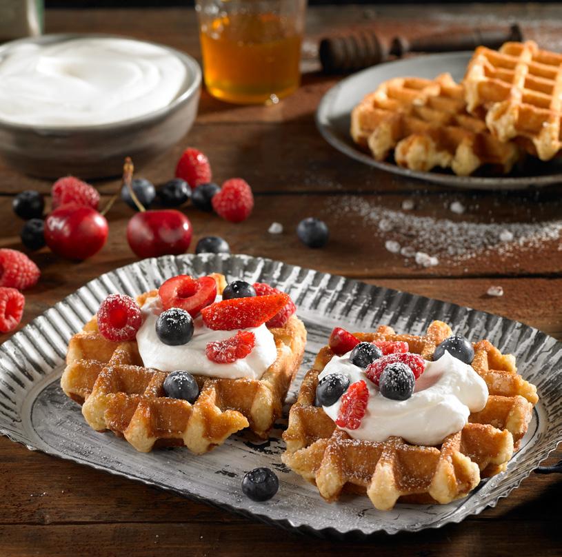 Belgian waffle with whipped cream and berries Whipped cream Berries: raspberries, strawberries and cranberries Icing sugar Mini portions of