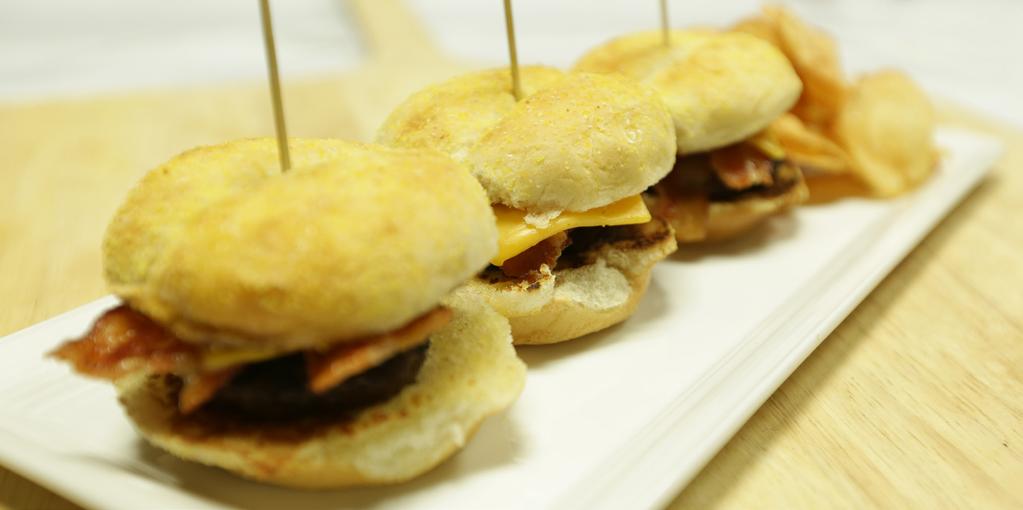 Sliders 3 x 2 oz. slider patties 2 pinches salt and pepper mix ¹ ₂ fl. oz. clarified butter or butter substitute 3 x 2 ¹ ₂ corn-dusted mini buns 3 cooked slices 13/17 bacon 1 ¹ ₂ slices Cheddar cheese 3 oz.