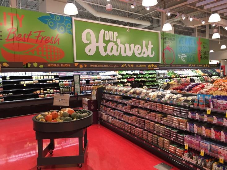 The fresh produce section is marked by a large overhead our Harvest