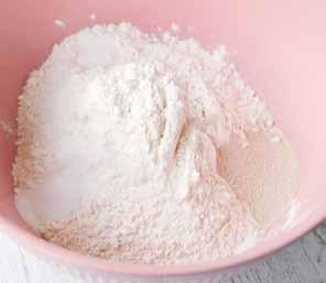 First measure the flour into a large mixing bowl. Add in 1 the yeast, sugar and salt, placing each in a different part of the flour.