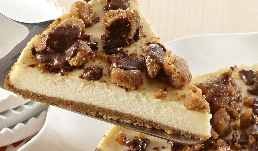 Creamy New York Style cheesecake topped with chopped pecans and drizzled with dark chocolate fudge