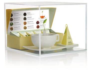 Dust-proof acrylic box displays an open Petite Presentation Box Assortment, a teacup with replicated steeping
