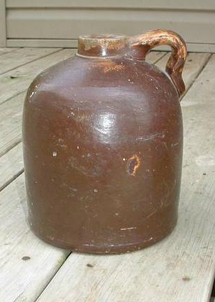 Whiskey jug passed down in the Rice family. The stoneware jug with brown Albany slip glaze is considered to have hand-produced locally.