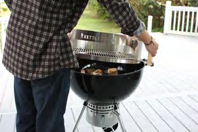 7. Holding the two handles, place the KettlePizza oven onto your kettle grill body and cover it with the grill lid.