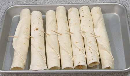 Then lift that edge, tuck it up against the filling, and tightly roll up the