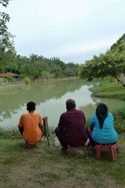 A family fishing together by the pond Fishing at Danau Pancing Damai allows you to experience the excitement and