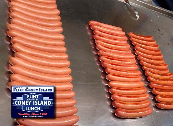Cooking the Koegel Coney Franks The flattop grill at Palace Coney Island in Genesee Valley Shopping Center, showing the stages of cooking the Coney Franks at very low heat, and the pickle fork used