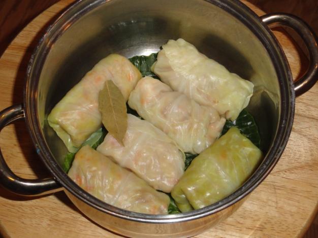 Lay down the cabbage rolls by layers, adding one or two bay leaves between
