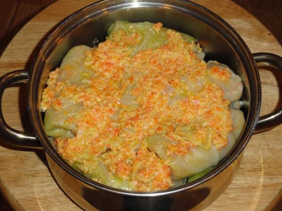 Pour and spread the second half of the onion-carrot mix on the top of the cabbage rolls. I do not add any water if I cook it in the oven.
