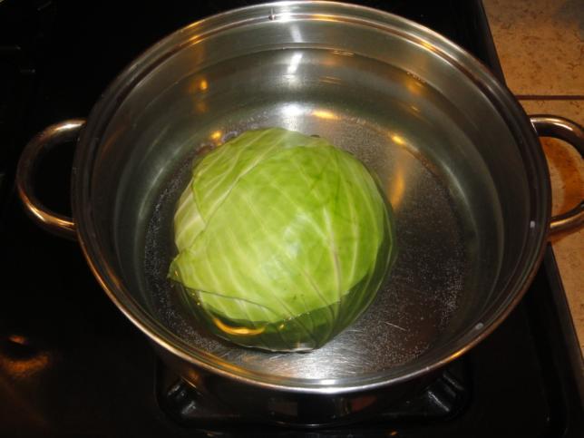 Put the cabbage into a pot of water, stem down, bring to boil. After water is boiling, cook for about 5 minutes on medium heat.
