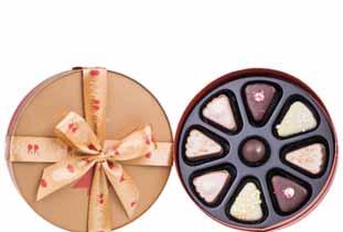 pieces of delicious cakes and an elegant round praline packed in a box