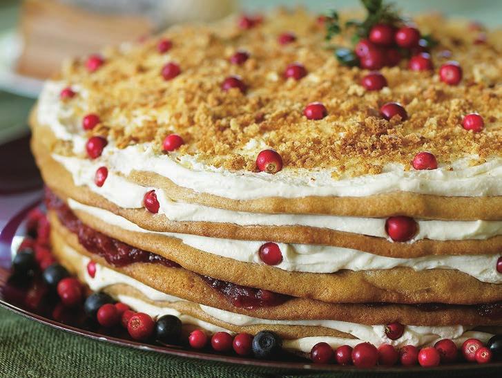 Fragrant honey pastry layers are filled with sour cream and the surface of the cake decorated with crumble, nuts or berries.