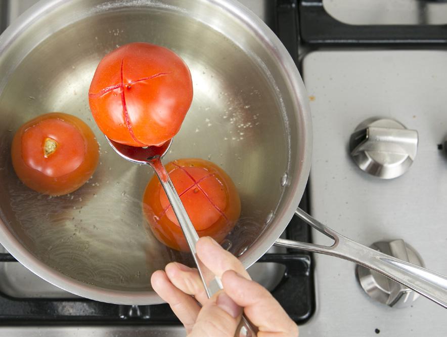 Cut a shallow X mark into the bottom of the tomatoes, then place them in boiling water until the skin starts to split and peel off, around 40 seconds.