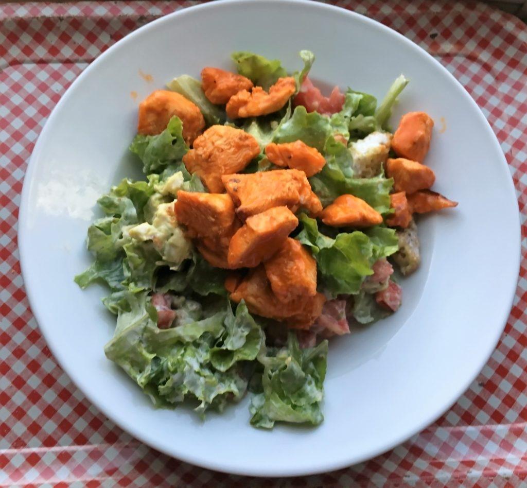 buffalo chicken salad 15 min cook time 10 min 4 Ingredients 2 boneless skinless chicken breasts, cut into 1" pieces 1/2-3/4 C Franks red hot sauce, divided 1 avocado, diced 12-16 oz fresh lettuce] 1