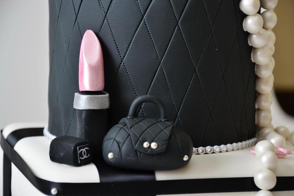 A bottle of Chanel No. 5, the world's best-selling fragrance, is perched on top of the cake. Open lipstick with the lid emblazoned with the Chanel logo, and a quilted purse and adorn the second tier.
