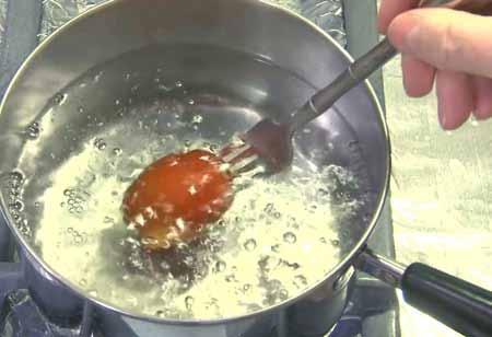 2 3 Pierce the tomato at the stem end with a fork and hold it below the surface of boiling