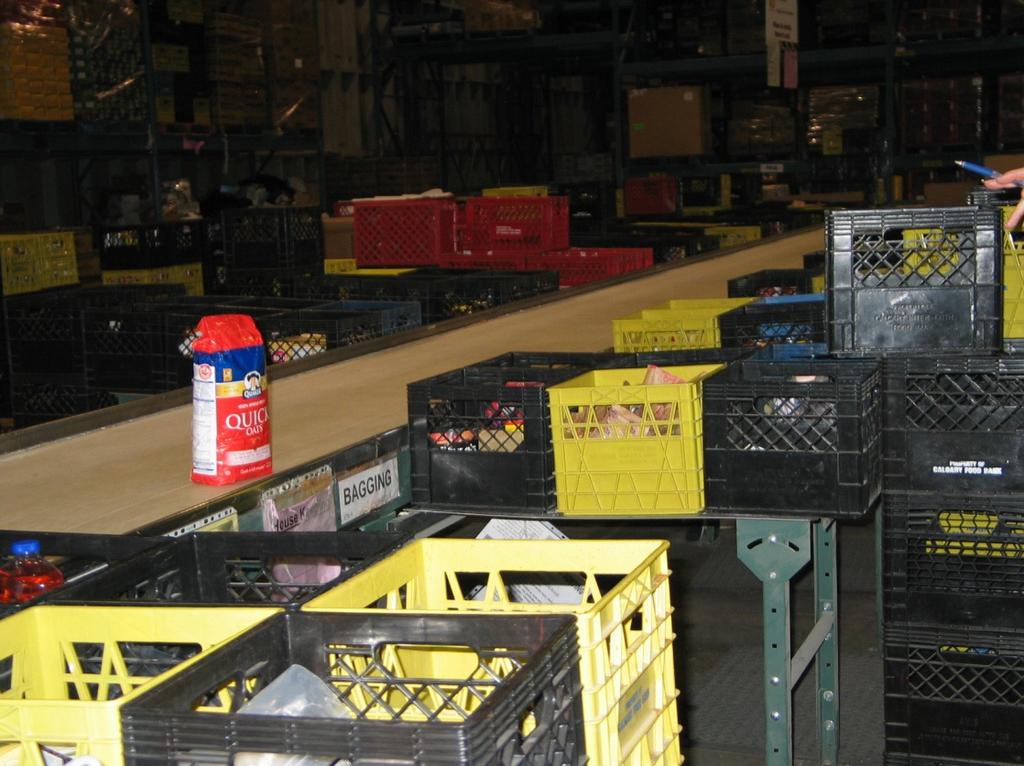Food donations move down a conveyor belt to be sorted at several stations.