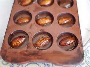 (This is done to stabilise the cocoa butter) Place the tempered Gianduja paste into a piping bag and fill Couverture chocolate lined mould to one-third Deposit one toasted Hazelnut into each
