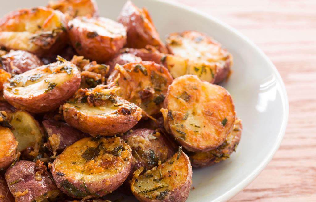 Herb Roasted Potatoes 31/2 tablespoons olive oil, divided 21/2 pounds baby red potatoes, sliced in half 3/4 cup shredded Parmesan cheese 3 cloves garlic, minced 1/4 cup chopped fresh parsley 2