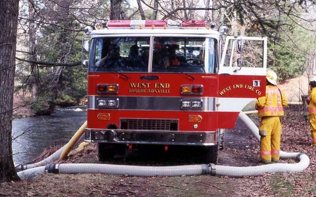 Slide 4 Figure 1. This 1250-gpm pumper is drafting from a shallow stream using dual suctions.