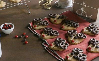 Reindeer Cookies 1 recipe Basic Sugar Cookies ½ recipe Royal Icing 72 mini regular or chocolate covered pretzels red and brown candy coated chocolates disposable piping bag Roll out dough to ⅜ inch
