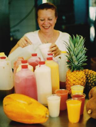 A woman is making fresh fruit shakes.